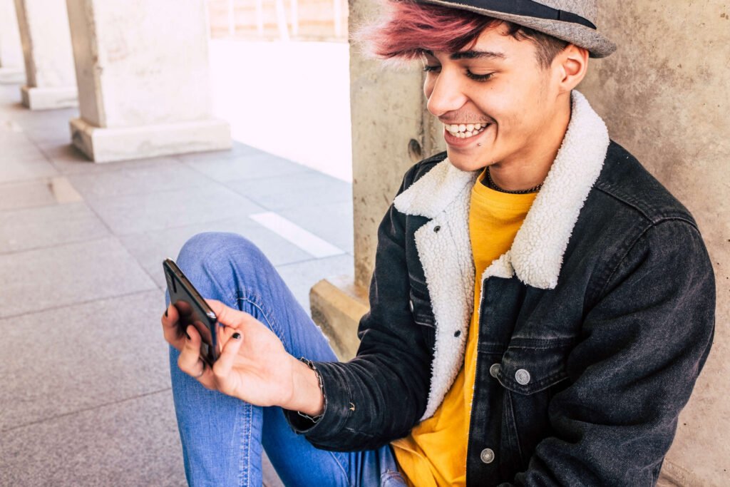 Gender-Fluid Individual smiling at phone. Depression in Teens and Depression in Adolescence is treatable. 