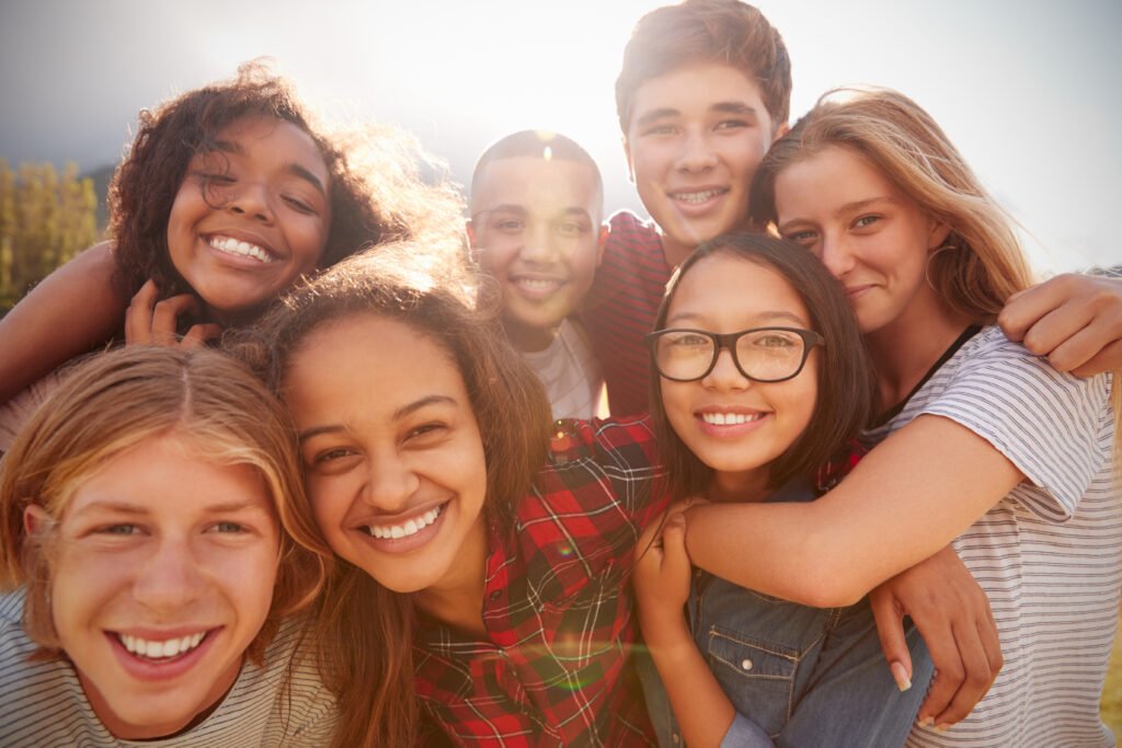 Diverse group of seven teens hugging each-other in a group picture. The Center for Emotional Wellness is an intensive outpatient program in Tampa FL